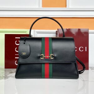 This handbag features a top-handle design Crafted from soft leather Black soft leather Black leather trim Gold-tone hardware Black canvas lining Detachable and adjustable leather shoulder strap Dimensions: 37 x 29 x 13 cm